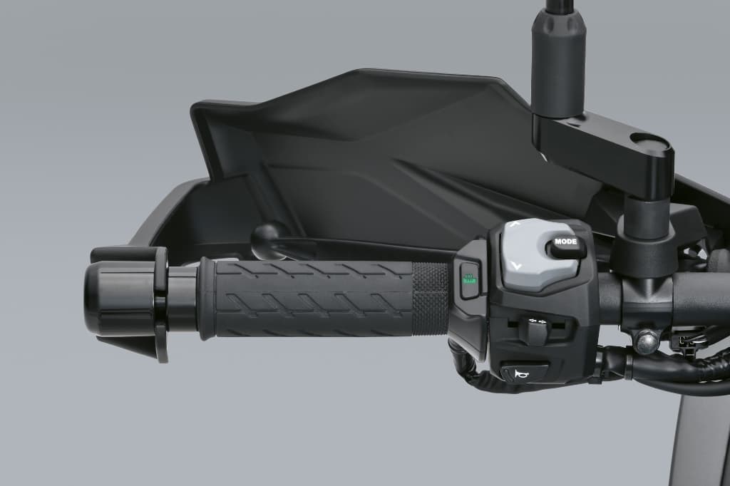 Beheizbarer Griff an einem Motorradlenker; Detailaufnahme des Griffs und der Steuereinheit mit MODE-Taste.