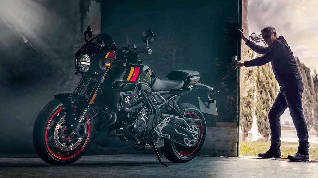 Motorradfahrer in schwarzer Schutzkleidung legt sich mit einer Suzuki GSX-8TT mit roten Felgen dynamisch in eine Kurve auf einer Bergstraße