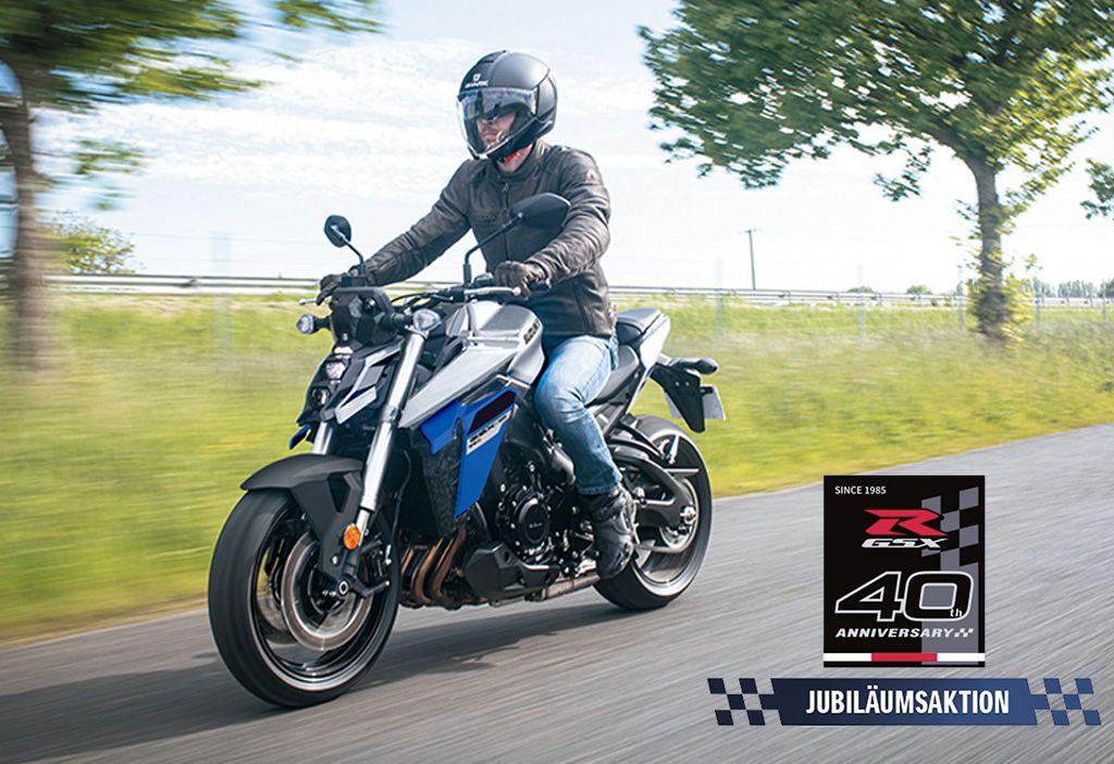 Eine blaue GSX-S950 auf einer Landstraße, rechts unten mit Jubiläumsaktions-Logo