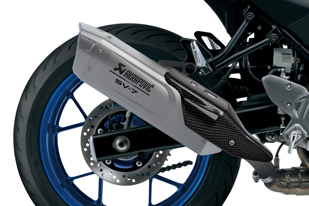 Motorradhinterrad mit blauem Felgenrand und Akrapovič SV-7 Auspuff mit Carbon-Abdeckung.