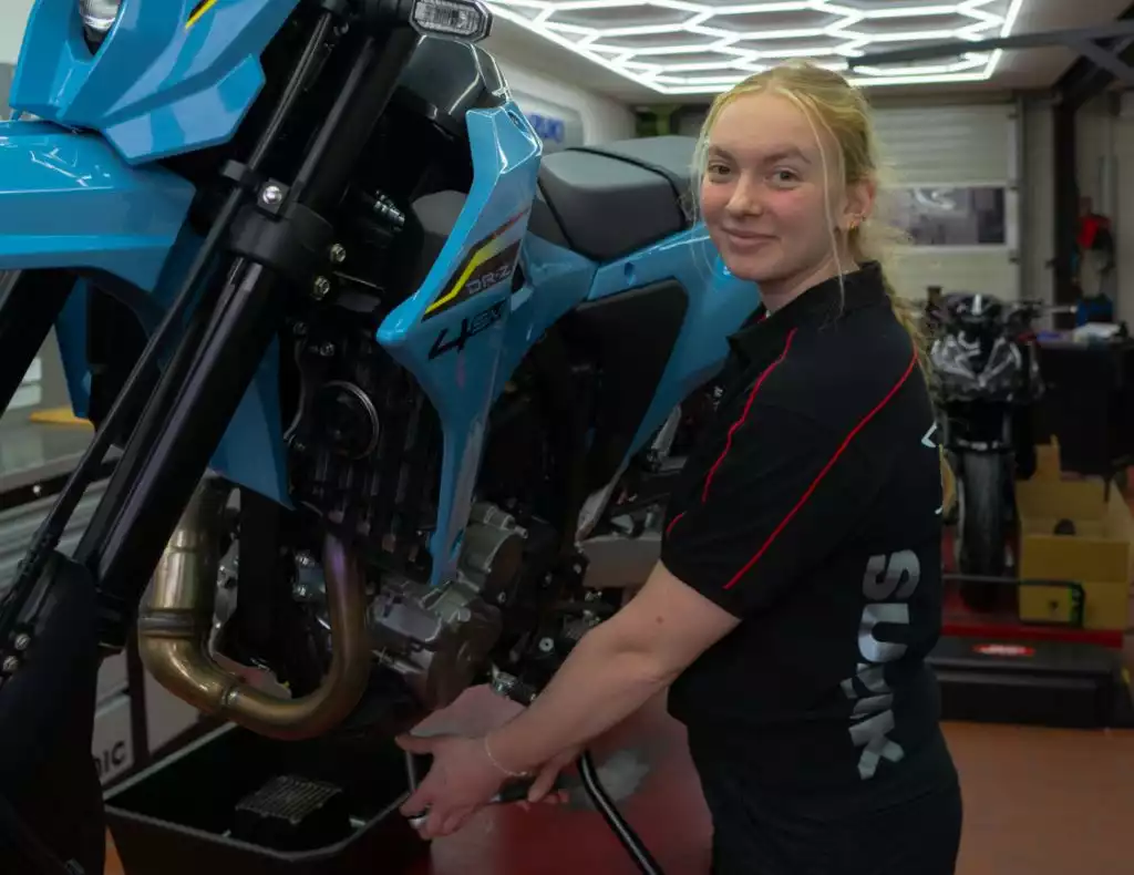 Paula van Zalk steht vor einem Suzuki Zeichen