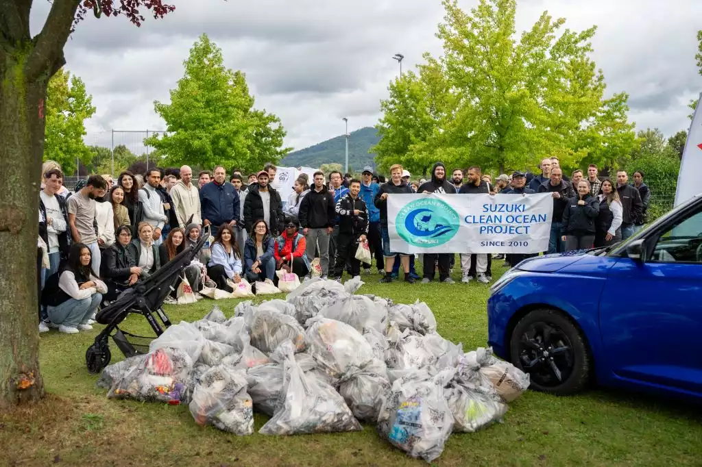 Suzuki Clean Ocean Project Gruppe vor einem Müllberg