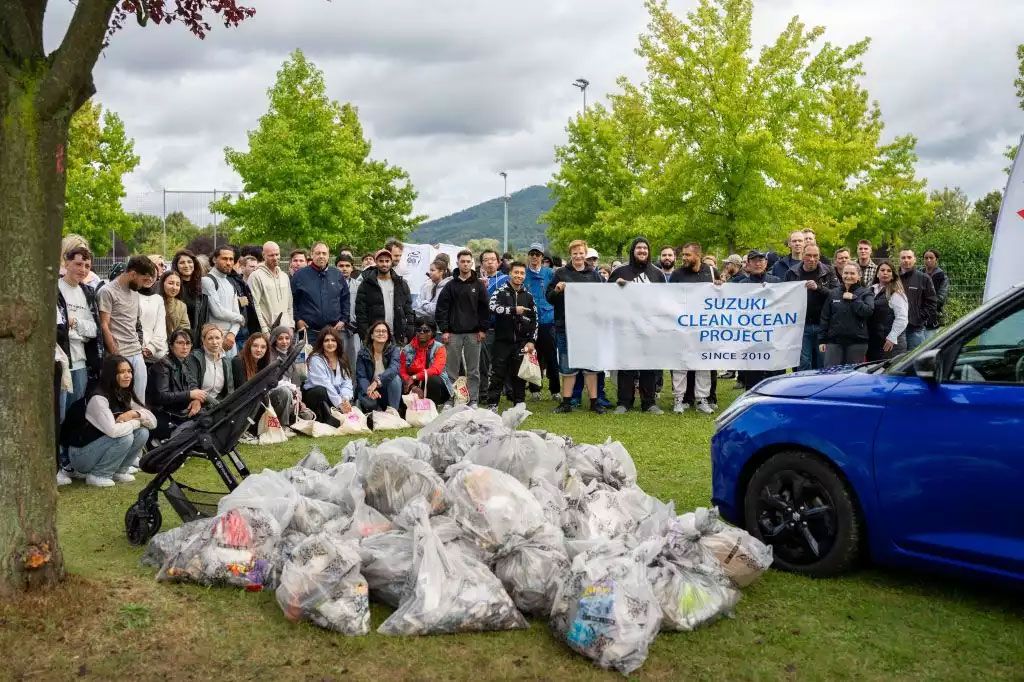 Suzuki Clean Ocean Project Gruppe vor einem Müllberg