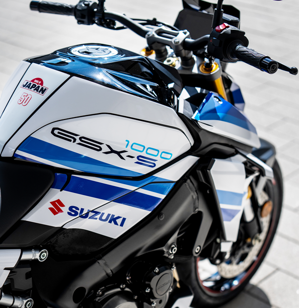 Nahaufnahme der Tankpartie der Suzuki GSX-S1000 Special Edition mit „GSX-S 1000“-Schriftzug, Suzuki-Logo sowie „Made in Japan“- und „50“-Aufkleber.