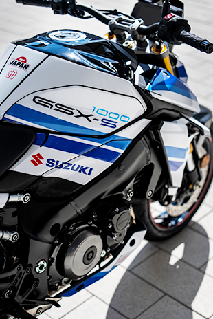 Nahaufnahme der Tankpartie der Suzuki GSX-S1000 Special Edition mit „GSX-S 1000“-Schriftzug, Suzuki-Logo sowie „Made in Japan“- und „50“-Aufkleber.