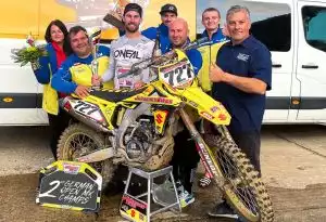 Siegreiches Suzuki Motocross Team feiert mit Pokal und gelbem RM-Z Bike den 2. Platz der German Open.