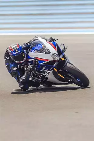 Suzuki GSX-R1000R Sportmotorrad in weiß-blau-rot, Kurvenfahrt auf der Rennstrecke
