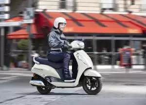 Person fährt Suzuki Address 125 Roller in urbaner Umgebung