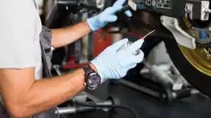 Mechaniker wartet Suzuki-Motorrad in Werkstattumgebung.