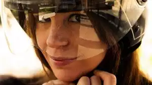 Frau mit Helm auf einem Suzuki-Motorrad, Nahaufnahme, Fokus auf Sicherheit und Fahrspaß.