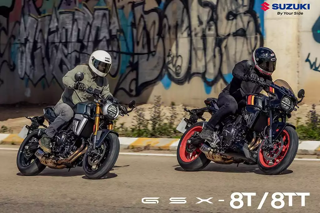 Zwei Fahrer auf Suzuki GSX-8T und GSX-8TT Motorrädern fahren dynamisch auf der Straße mit Graffiti-Hintergrund.