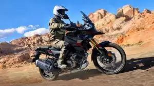 Fahrer auf Suzuki V-Strom 1050DE in Wüstenlandschaft, Adventure-Bike auf Schotterpiste.