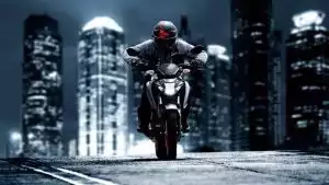 Fahrer auf Suzuki Naked Bike bei Nacht, Frontansicht vor Skyline, LED-Scheinwerfer