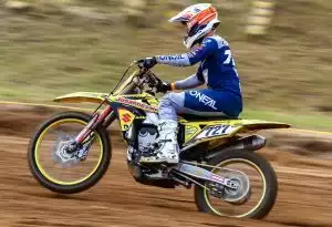 Motocross-Fahrer auf Suzuki-Motorrad in Aktion auf einer Rennstrecke.